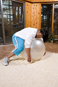 精疲力竭的女人在健身球上睡着了图片
