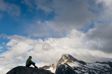 一个女人坐在山上图片
