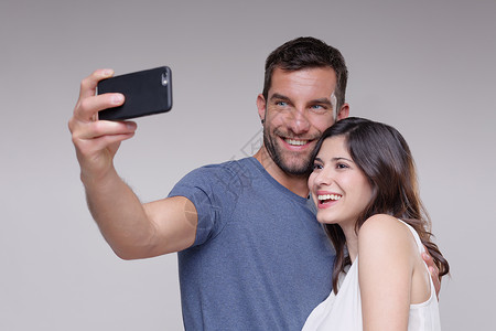 异性恋伴侣使用智能手机自拍背景图片