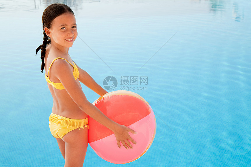 游泳池旁有沙滩球的女孩图片
