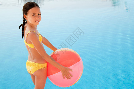 游泳池旁有沙滩球的女孩图片