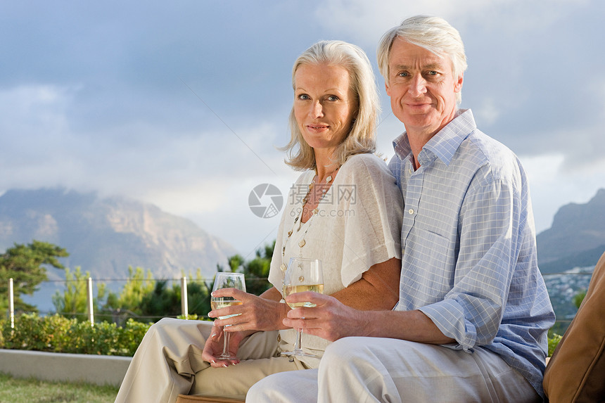 一对中年夫妇端着酒杯在外面放松图片