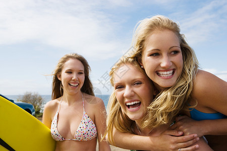 拿冲浪板女孩在海边玩得开心的女孩背景