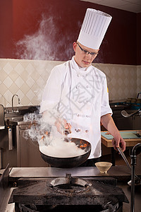 男厨师在商业厨房用炒锅煎图片