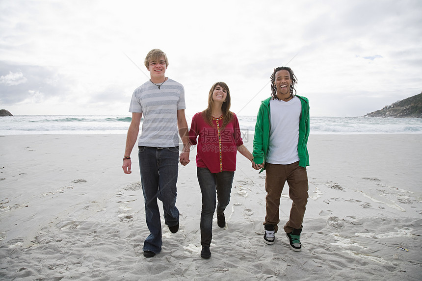 三个人手牵着手在海滩上散步图片