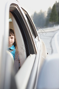 小孩开窗坐在汽车后座的男孩背景