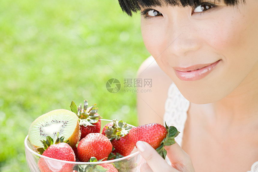 一碗水果的年轻女子图片