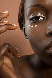 年轻女子在脸上涂润肤霜背景图片