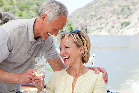 在船上度假时带着酒杯的老年夫妇高清图片