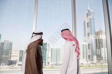 中东商人透过办公室窗户看迪拜图片