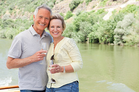 多罗河在船上度假时带着酒杯的老年夫妇背景