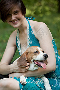 抱着宠物小猎犬的女人背景图片
