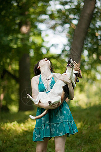 抱着宠物小猎犬的女人背景图片