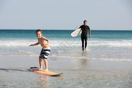 小男孩在浅水中冲浪高清图片