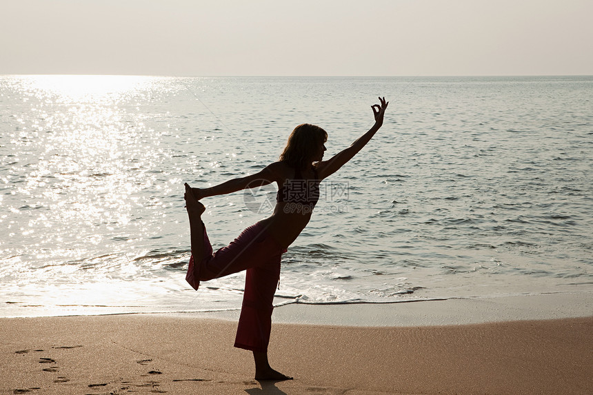 在日落时分练习瑜伽的女人图片