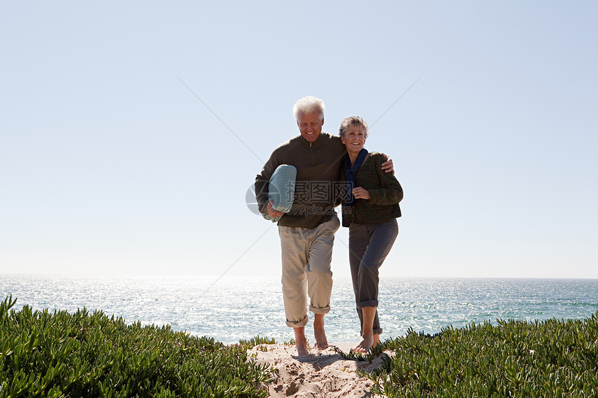 在沙丘上行走的成年夫妇图片