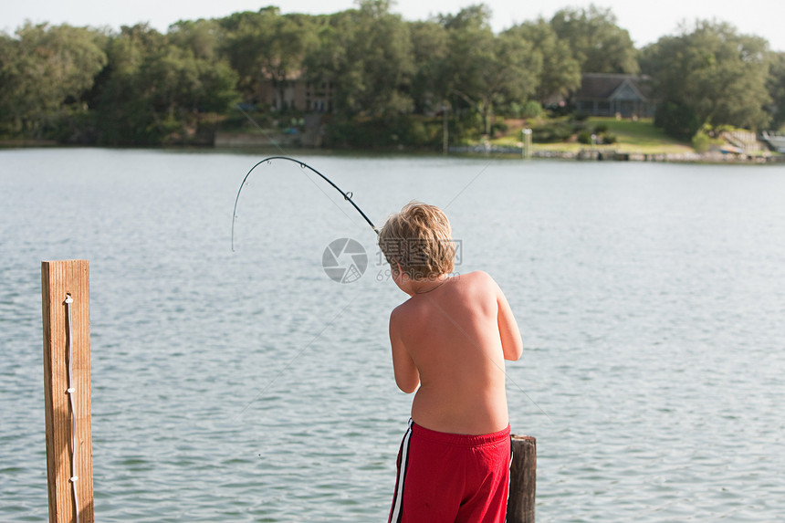 男孩在湖里钓鱼图片