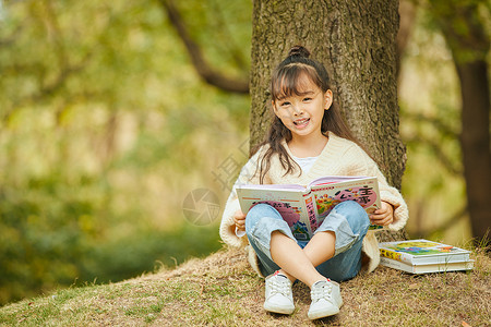 小女孩户外看童话书高清图片