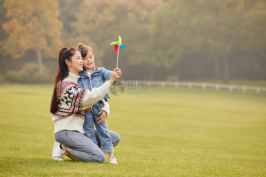 可爱母女草坪上玩风车图片