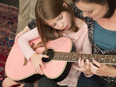 给女儿弹吉他快乐弹吉他的母女背景