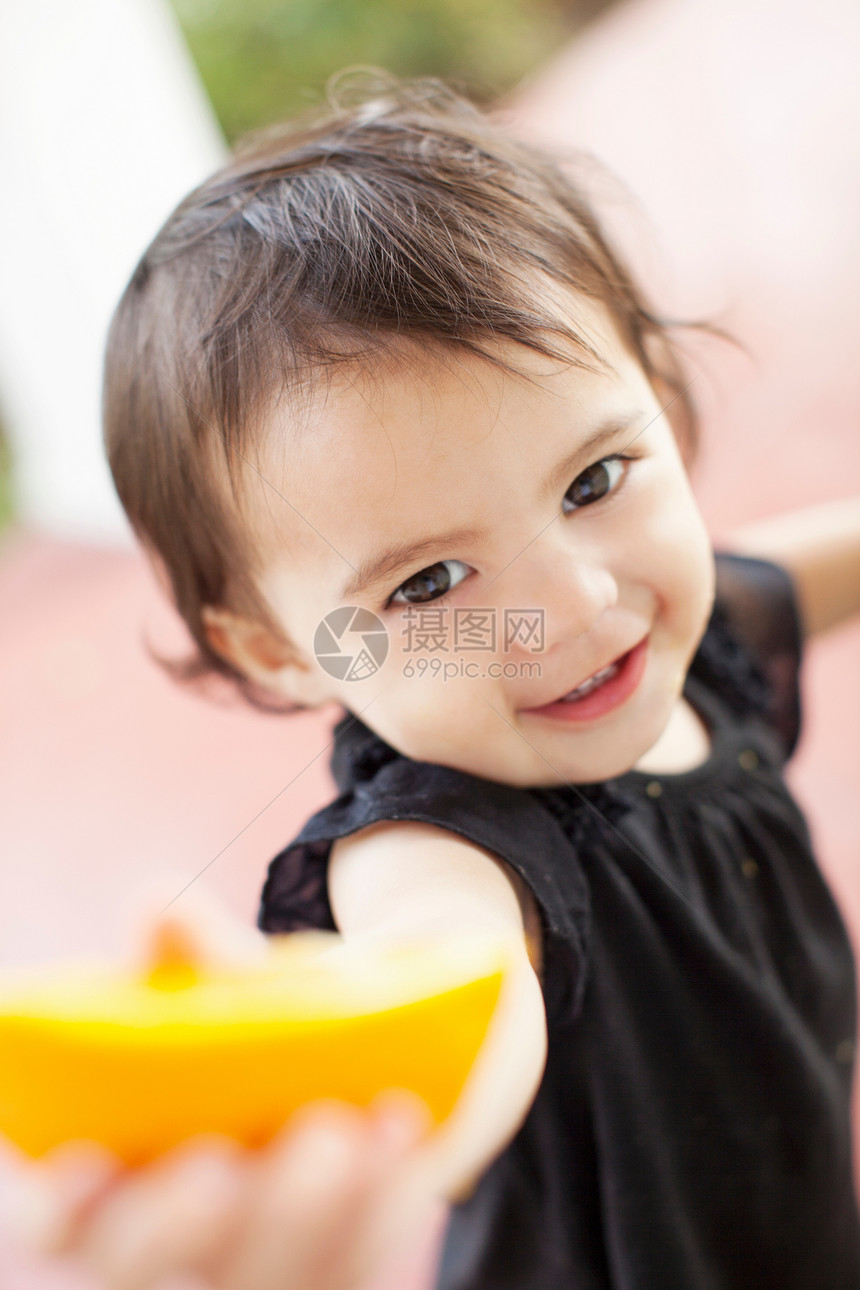 女婴举着橘子特写图片
