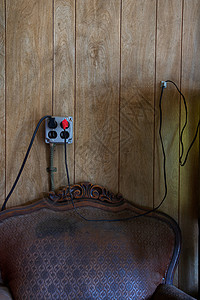 旧椅子上方的电源插座和电线图片
