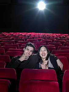 坐在空荡荡的电影院里的年轻夫妇图片