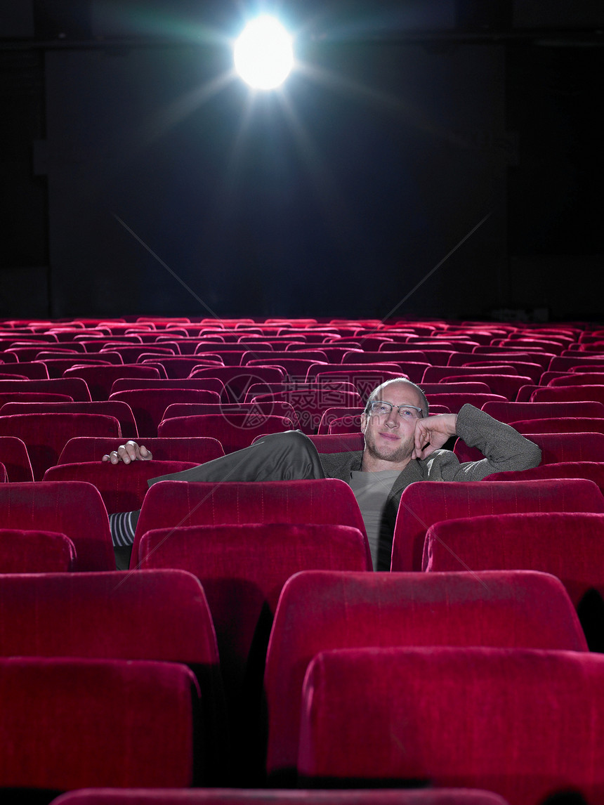 成熟的男人在空旷的电影院里放松图片
