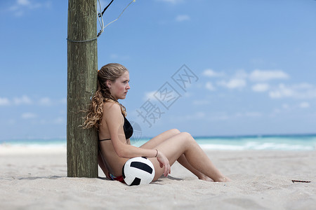 沙滩上打排球的年轻女子图片