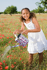 小女孩用水壶浇灌图片