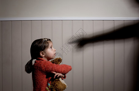 小女孩和玩具吓坏了的小女孩和大人用手指着她的影子背景