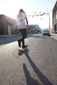 阳光下的城市街头滑板手图片