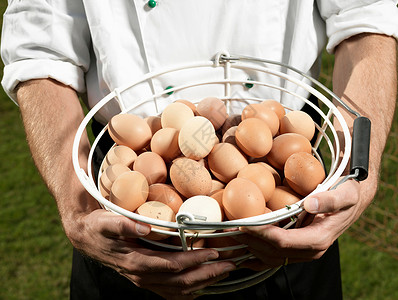 厨师拿着装满鸡蛋的篮子图片