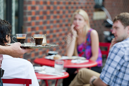 为咖啡馆外的人准备咖啡的服务员图片