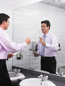 在办公室卫生间镜子里练习演讲的男人图片