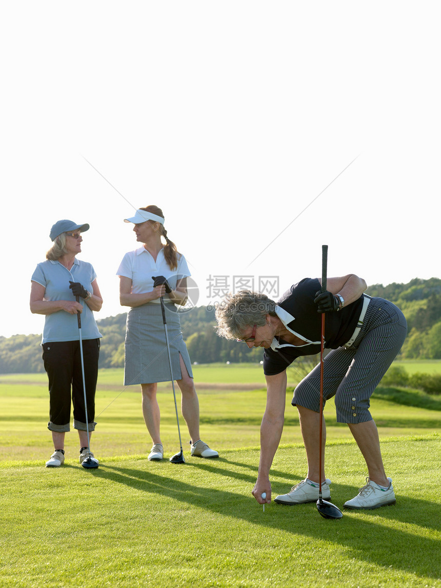 三位高尔夫女士在球座图片