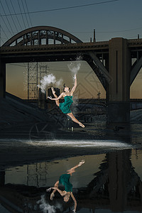 美国洛杉矶日落时分女芭蕾舞演员在河上跳跃图片