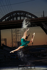 美国洛杉矶日落时分女舞者在释放火药爆炸的同时跳跃背景图片