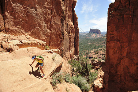 美国亚利桑那州塞多纳的女性徒步岩石地层背景图片