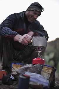 背包客在美国亚利桑那州迷信山的野营炉上准备食物背景图片