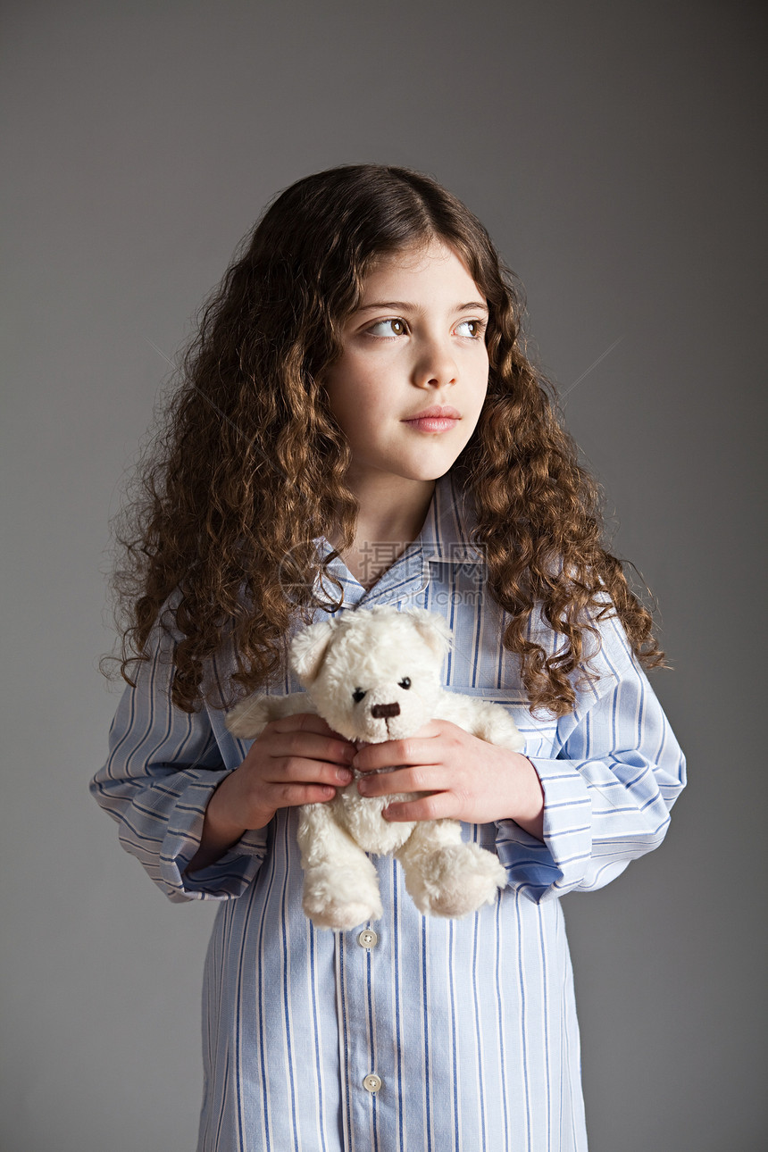 穿着睡衣抱着泰迪熊的小女孩图片