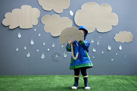 蓝色雨带雨伞和雨衣的女婴背景