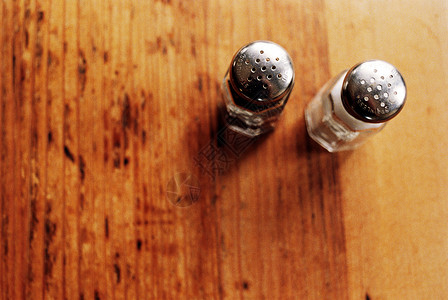 木桌上的盐和胡椒罐高清图片