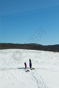 母亲和两个孩子在雪地图片