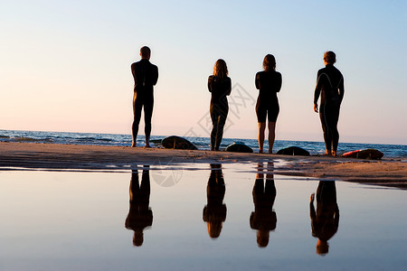 四个人站在沙滩上背景图片