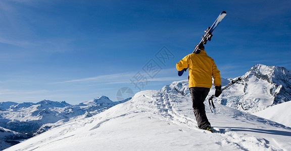 黄色树懒滑雪走过山脊的滑雪者背景