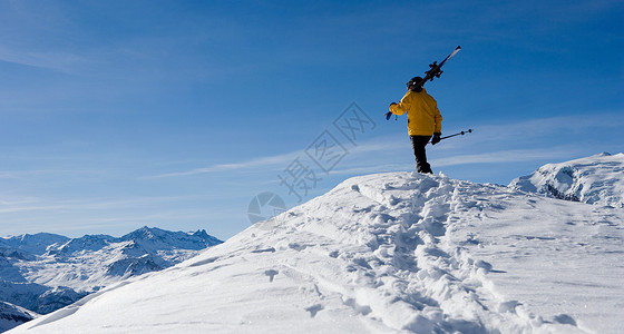 男人滑雪站在山顶的滑雪者背景