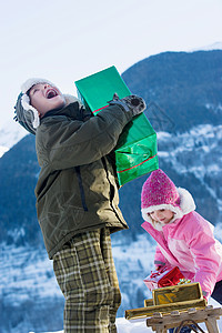 礼物山男孩和女孩在雪地里拿礼物背景