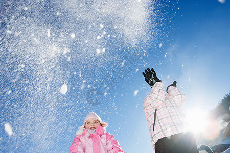 向空中扔雪的年轻女孩图片