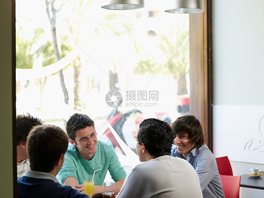 一群年轻男性在咖啡馆交谈图片